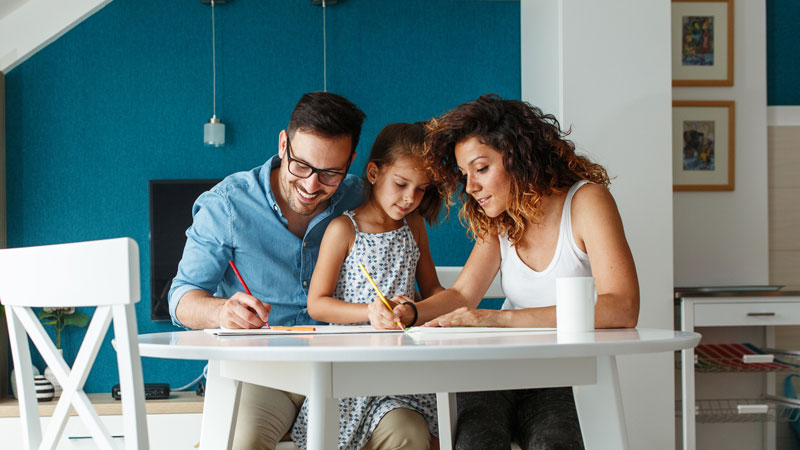 Mother and Father helping their daughter with her homework